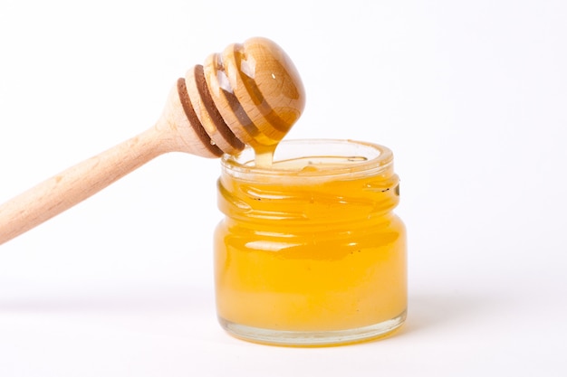 Honing die van een houten honingsdipper druipt