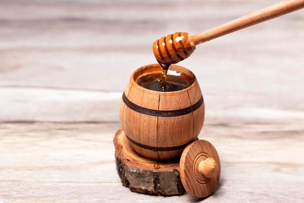 Foto honing druipend van honingdruppelaar in een houten vat