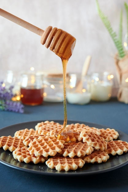 Honing gieten over een bord met vers gebakken wafels