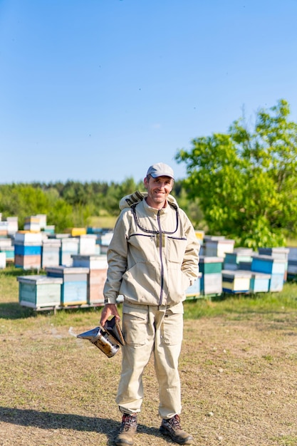 Honing hobby landbouw Bijenteelt man in pak en masker werken in de bijenstal