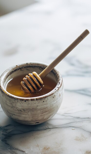 Honing in een keramische schaal met honingdipper op de marmeren tafel met verticale oriëntatie
