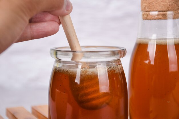 Honing in pot met honingdipper op witte achtergrond Copyspace voor uw tekst