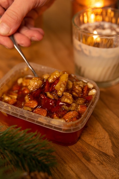 honing met noten en fruit die uit een pot druipen in een kerstmis-nieuwjaar-interieur op een houten tafel