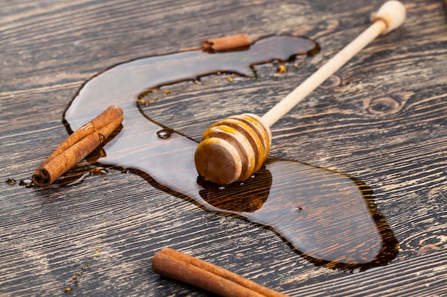 Honing verspreidt zich op tafel een close-up van honing en honinglepels op een houten tafel