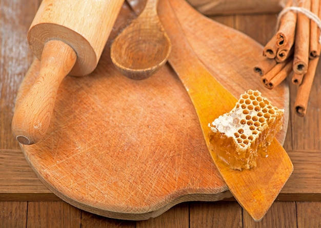 Honingdipper en honingraat met lavendel, kaneel en anijs op houten oppervlak