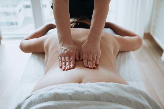 Honingmassageconcept Gezondheidszorgconcept Massagetherapeut die massage met een massageborstel doet