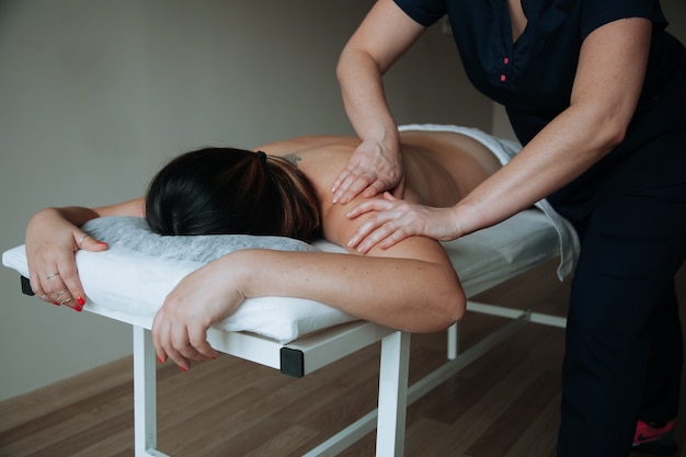 Honingmassageconcept Gezondheidszorgconcept Massagetherapeut die massage met een massageborstel doet