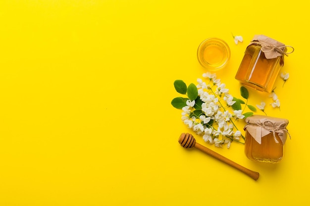 Honingpot met acacia bloemen en bladeren verse honing bovenaanzicht plat liggend