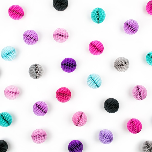 Honingraat ballen decoratie patroon. Roze, lila en turquoise papieren pom pom op een witte achtergrond. Plat leggen. Vakantie concept