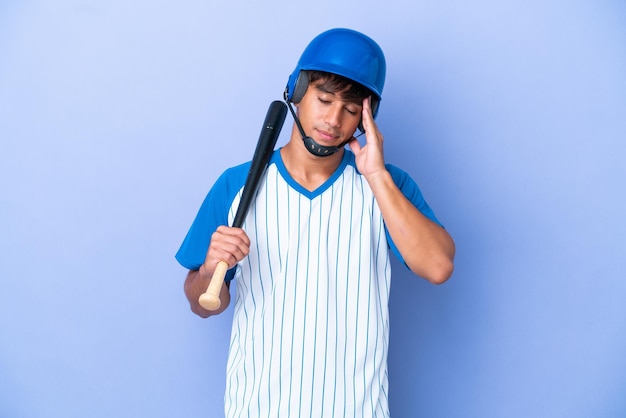 Honkbal blanke man speler met helm en vleermuis geïsoleerd op blauwe achtergrond met hoofdpijn