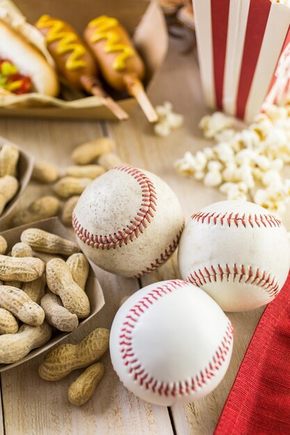 Honkbal feest eten met ballen en handschoen op een houten tafel.