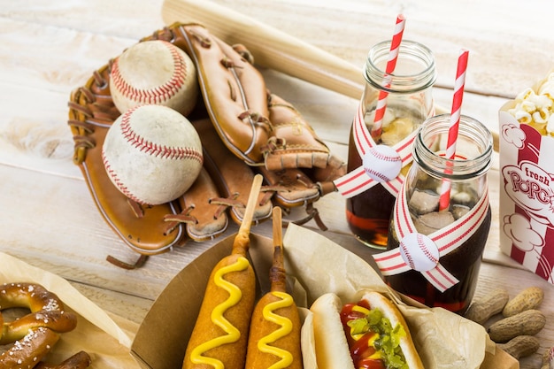 Honkbal feest eten met ballen en handschoen op een houten tafel.