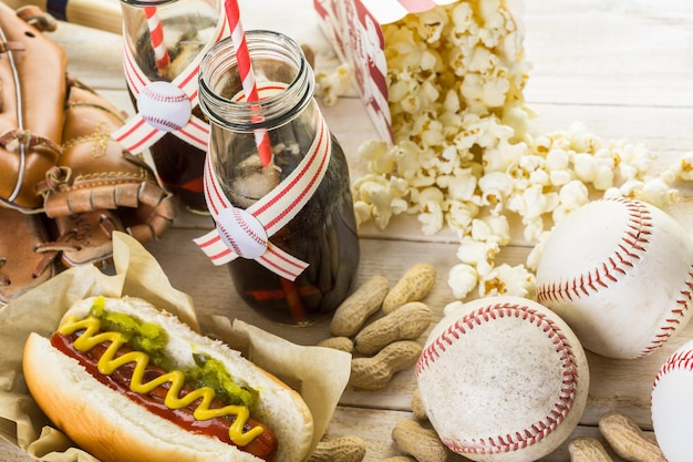 Honkbal feest eten met ballen en handschoen op een houten tafel.