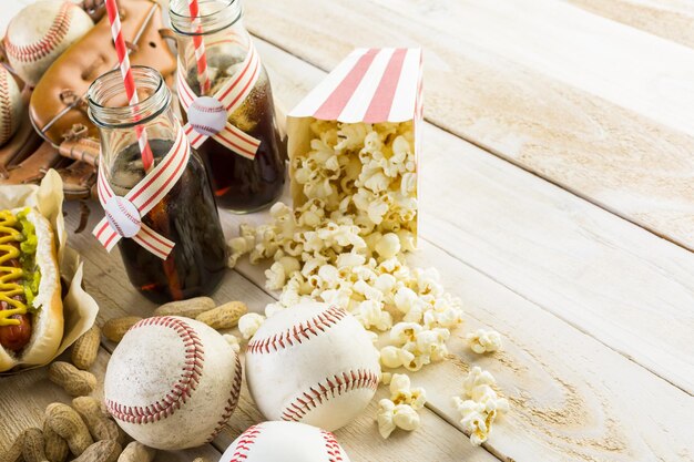 Honkbal feest eten met ballen en handschoen op een houten tafel.