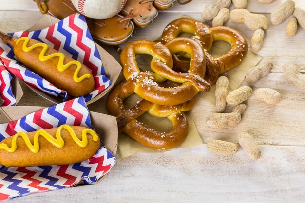 Honkbal feest eten met ballen en handschoen op een houten tafel.