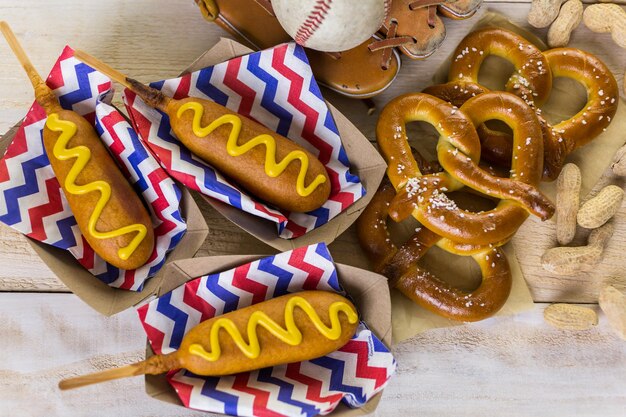 Honkbal feest eten met ballen en handschoen op een houten tafel.