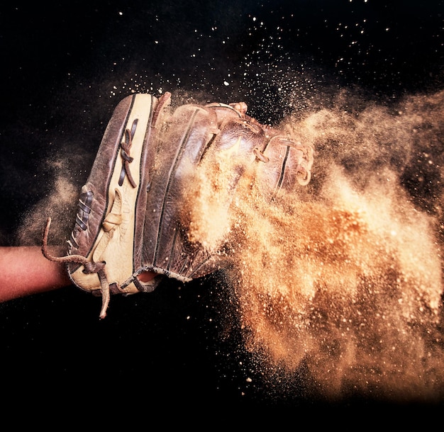 Honkbal spel handschoen en vuil studio achtergrond voor vangst actie in sportwedstrijd Geïsoleerde lederen softbal atleet apparatuur voor score in toernooi met zwarte muur voor mock up