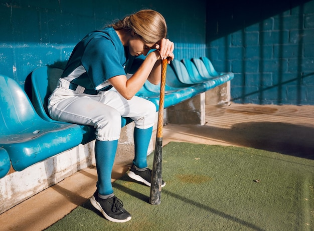 Foto honkbal sportbank en vrouw atleet boos denken aan spelverlies tijdens het wachten om te spelen gefrustreerd verdrietig en serieus softbal speler meisje in depressieve stemming voor professionele wedstrijdmislukking