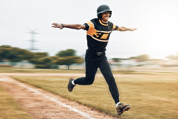 Honkbalman en rennende viering op honkbalveld na het scoren van homerun Oefening fitness en winnende honkbalspeler uit India viert succes op grasveld na trainingswedstrijd