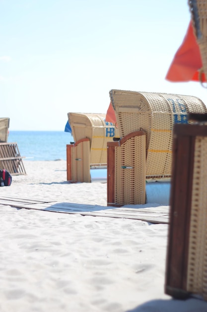 Hooded beach chair on sand against sky