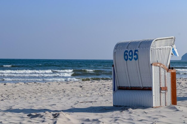 Photo hooded beach chair on shore against clear sky