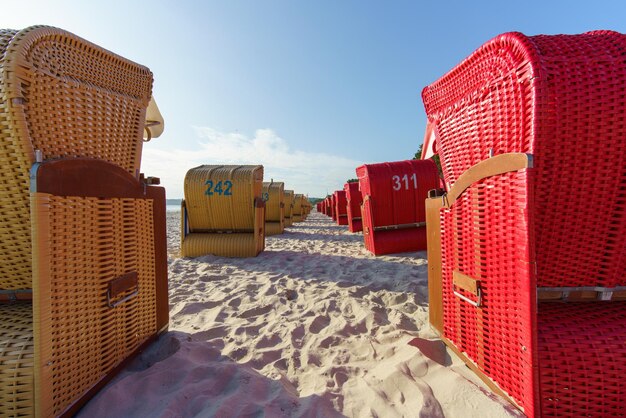 Photo hooded beach chairs by sea against sky