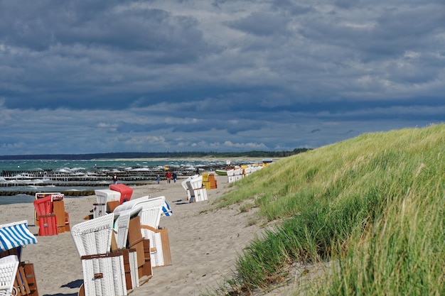 Photo hooded beach chairs by sea against sky