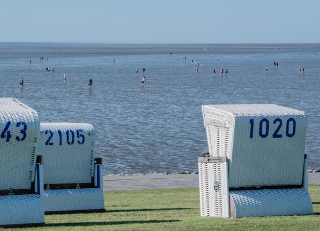 Photo hooded beach chairs on shore against sky