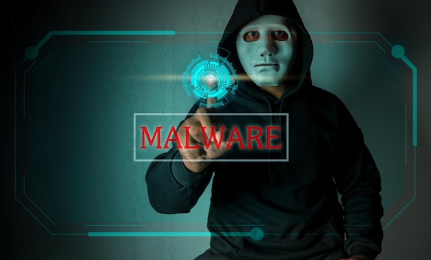 Хакер в капюшоне использует свои руки, чтобы нажать кнопку на экране в воздухе, чтобы атаковать конфиденциальные данныеВзлом и концепция вредоносных программ