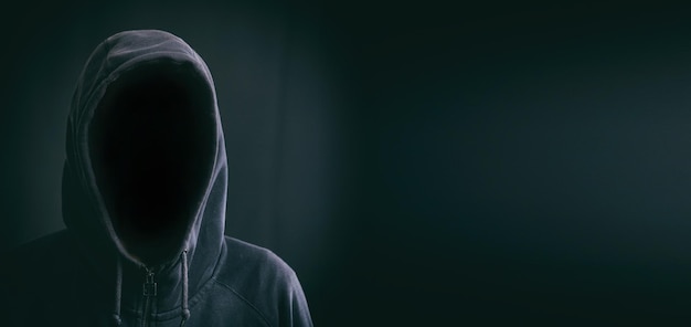 Hooded man on black background