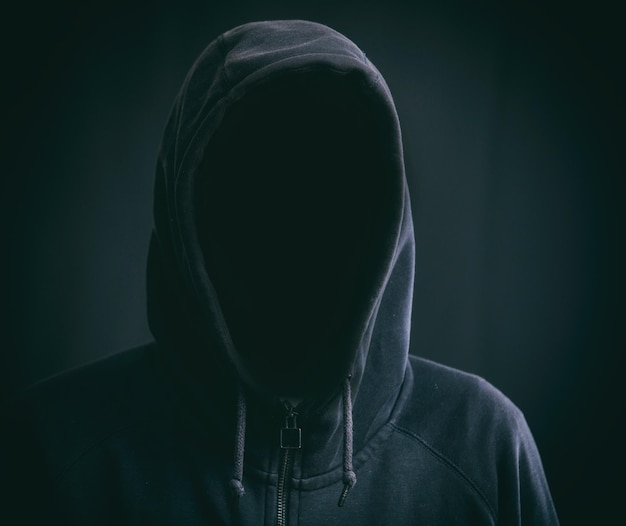 Hooded man on black background