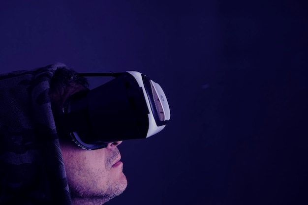 Hooded man ware virtual reality bril donkere achtergrond