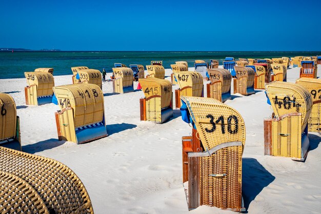 Foto hooded stoelen op het strand tegen de blauwe hemel