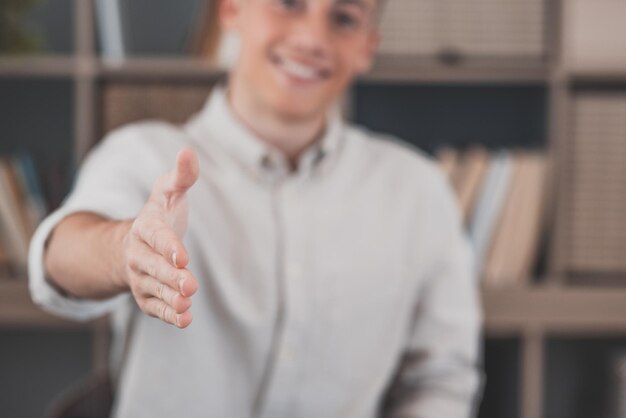 Foto hoofd geschoten portret lachende zakenman met bril hand uitstrekken voor handdruk naar camera vriendelijke hr-manager groet kandidaat op interview biedt deal gastvrije klant op vergaderingxa