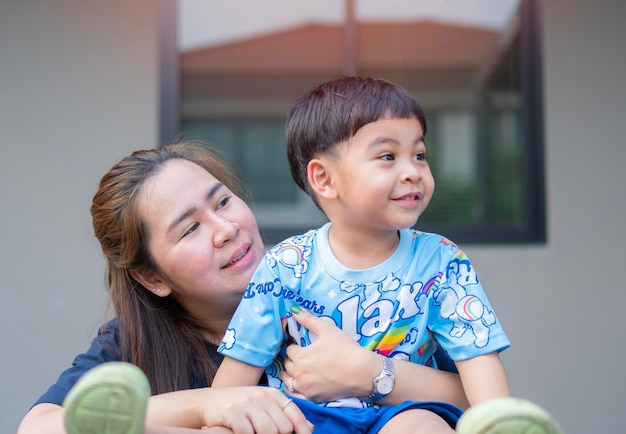 Hoofd schot gelukkige jonge Aziatische vrouw knuffelen praten met kleine kind zoon