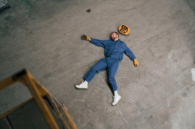 Foto hoofdbeeld van een dode fabrieksarbeider die op de grond ligt