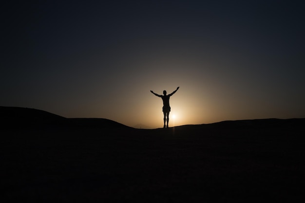 Hoofddoel bereiken silhouet man staat trots voor zonsondergang hemelachtergrond Toekomstig succes hangt nu af van uw inspanningen Dagelijkse motivatie Gezonde levensstijl persoonlijk prestatiedoel en succes