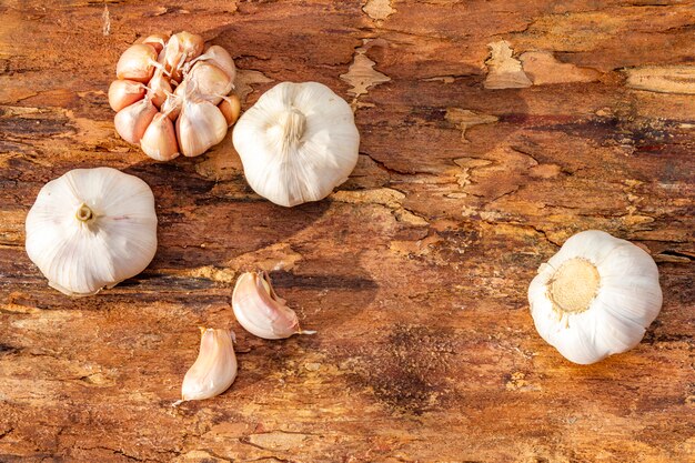 Hoofden van knoflook op een houten schors oppervlak. Ingrediënt voor het koken.