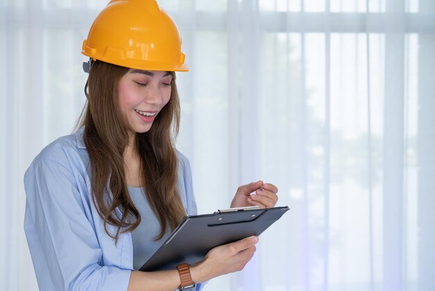 Hoofdingenieur vrouw in gele helm controleer de juistheid van de constructie