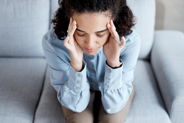 Foto hoofdpijn stress en angst met zwarte vrouw op de bank voor burn-out geestelijke gezondheid en verdrietig depressie denken en gefrustreerd met meisje in de woonkamer die lijdt aan een probleem, bezorgd en uitgeput