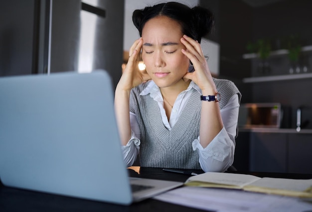 Hoofdpijn, stress en vrouw op laptop glitch en burn-out tijdens het werken 's nachts in een keuken Moe ondernemer en bedrijf falen door Aziatische werkneemster gefrustreerd door online project en fout