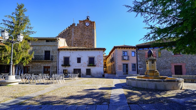 Hoofdplein met fontein en muurtoren met klok. Buitrago de Lozoya, Madrid.