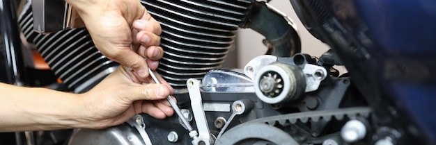 Hoofdreparateur die motorfiets in workshopclose-up herstellen