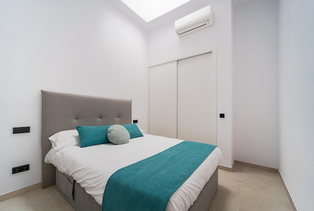 Hoofdslaapkamer in wit met een tweepersoonsbed, airconditioning en een kledingkast op een nieuwbouwwoning