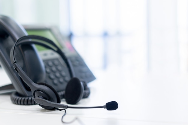 Hoofdtelefoon met telefoonapparaten bij bureau