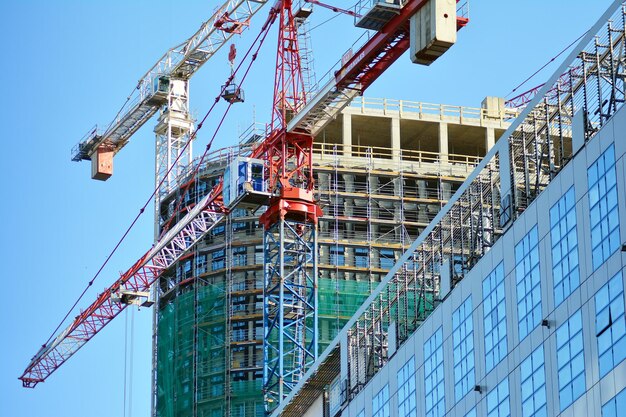Foto hooggebouw in aanbouw installatie van glazen gevelpanelen op een gewapend beton