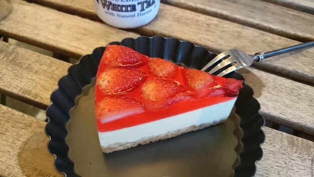 Hooghoek uitzicht op aardbeien tofu cheesecake in plaat op tafel
