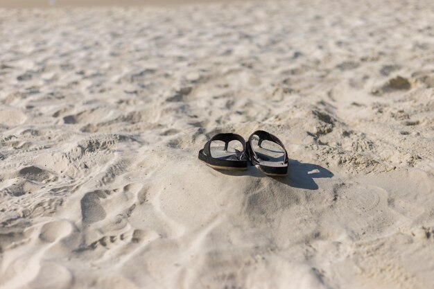 Hooghoek van schoenen op het zand op het strand