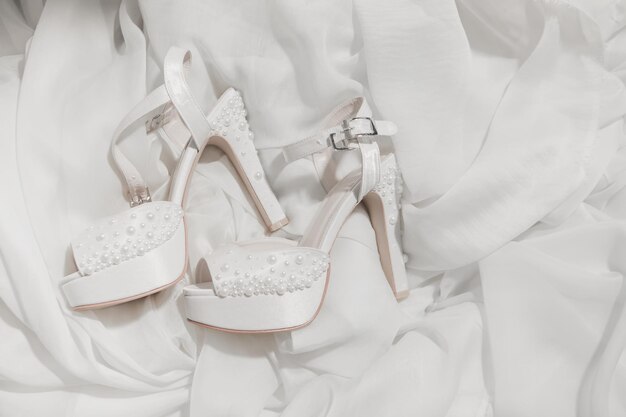 Foto hooghoek van witte schoenen op het bed