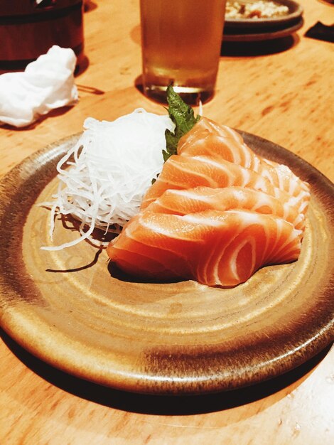 Foto hooghoek van zalm sashimi in bord op tafel